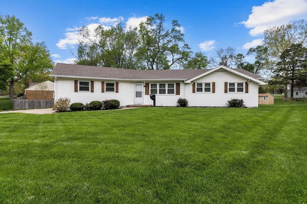 A single-story house with a front porch, a garage, and a well-maintained lawn.