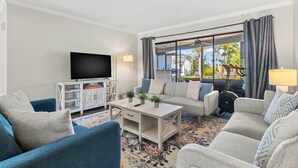 A living room with a TV, sofa, and armchairs, a coffee table, and a view of the outdoors. - Family Home with Heated Pool_6 Mins from the Beach (Largo)