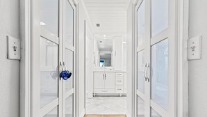A hallway leading to a kitchen with white cabinetry and a tiled floor. - Family Home with Heated Pool_6 Mins from the Beach (Largo)