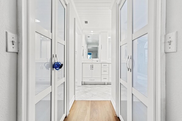 A hallway leading to a kitchen with white cabinetry and a tiled floor. - Family Home with Heated Pool_6 Mins from the Beach (Largo)