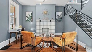 Uma sala de estar moderna com lareira, área de refeições e escada.