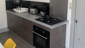 A modern kitchen with a gas stove, oven, and toaster. - Gîte des Serves apparently 40m2 Chavanay 5 people (Chavanay)