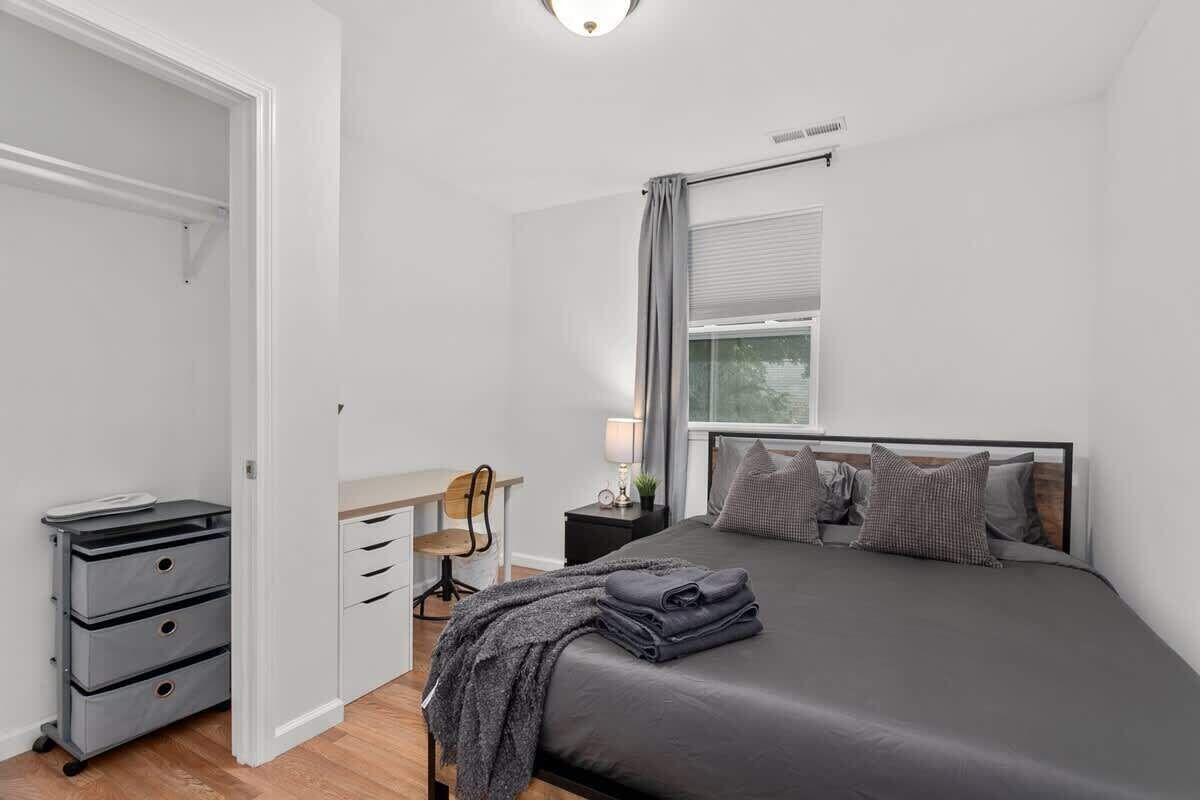 A bedroom with a bed, a desk, a chair, and a wardrobe.
