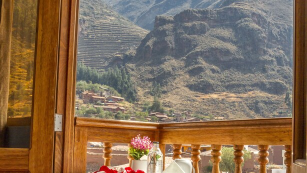 A balcony with a view of terraced fields and mountains. - Pisonay Hotel (Pisac)