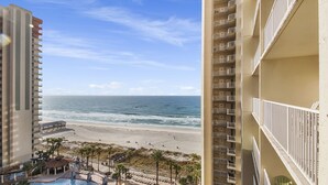A beachfront hotel with multiple balconies, a pool area, and a view of the ocean. - Beachfront Paradise with Reserved Parking (Panama City Beach)