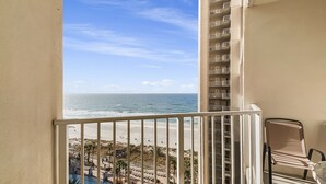 A balcony with a view of the beach and ocean. - Beachfront Paradise with Reserved Parking (Panama City Beach)