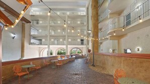 A spacious indoor courtyard with a brick floor, multiple seating areas, and string lights. - Beachfront Paradise with Reserved Parking (Panama City Beach)