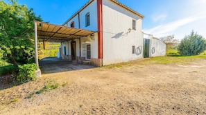 A two-story building with a covered entrance and a dirt ground. - Huerta Nueva Cuevas del Becerro by Ruralidays (Málaga)