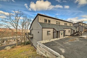 En bostadsbyggnad med garage, en täckt uteplats och en trappa som leder upp till de övre våningarna.