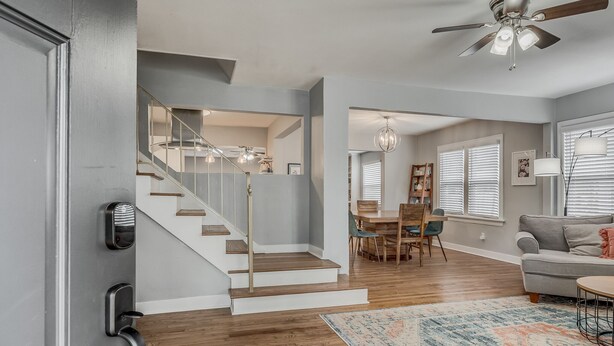 Un interior moderno con una escalera, comedor y sala de estar.
