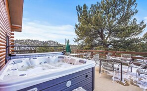 Relax in the hot tub surrounded by a serene forest view.