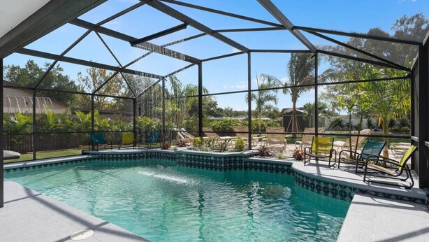 Una piscina techada con vistas al jardín y árboles circundantes.