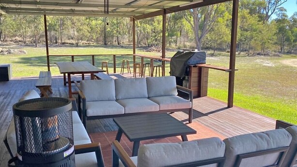 An outdoor patio with a sofa, tables, and a grill. - Spacious Country Home (Mount Tully)