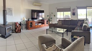 A living room with a fireplace, a television, a sofa, and a coffee table. - Spacious Country Home (Mount Tully)