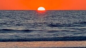 A sunset over the ocean with calm waves. - Surf, Relax and Explore the best of Avellanas (Playa Avellanas)