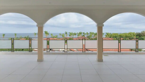 A covered outdoor area with a view of the sea and palm trees. - Atlantic Luxury Apartments (Penthouse) (cape point)