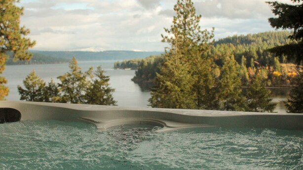 A hot tub with a view of a lake and forest. - Coeur d'Alene Lake House - Hot Tub with lake view, beach/lake access/boat launch (Worley)