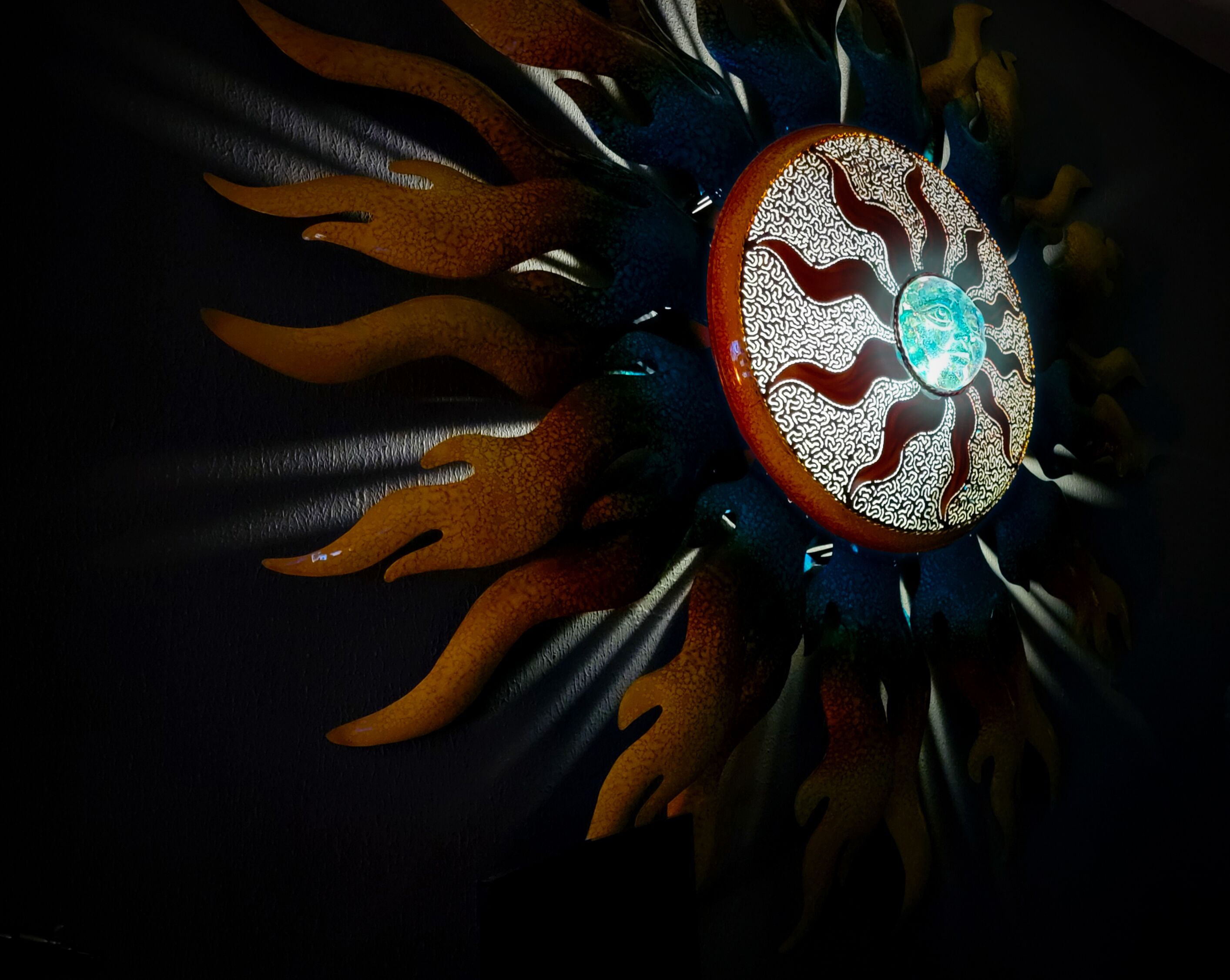 A circular object with a central glowing blue light and a patterned design.