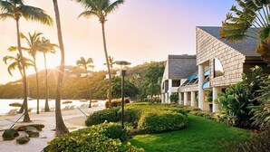 Un resort con piscina, palmeras y vista al océano.