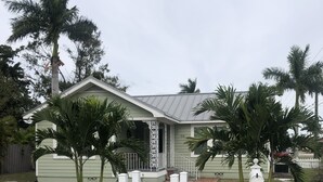 Une maison avec une clôture blanche en bois, un porche et une boîte aux lettres.