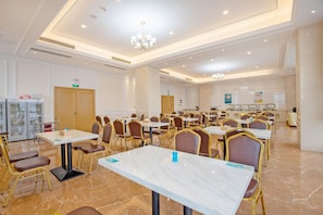 A conference room with marble tables, gold chairs, and a chandelier.