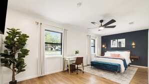 A bedroom with a bed, desk, chair, and a ceiling fan. - Bellini House / Modern 3BD Near Dallas (Richardson)