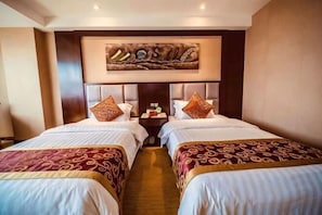 A hotel room with two beds, a nightstand, a wall-mounted artwork, and a headboard.