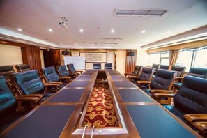 A conference room with a long table and multiple chairs, a whiteboard, and a decorative carpet. - Ru Jiang Hotel (Zhong County)