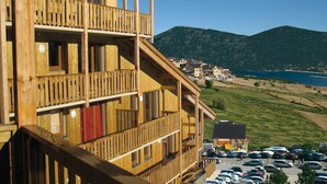 A wooden building with multiple balconies overlooking a coastal area.