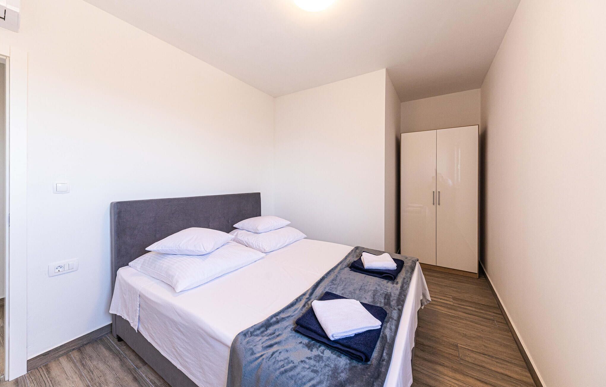 Ein Hotelzimmer mit einem Bett, einem Kleiderschrank und einem Nachttisch mit Handtüchern.