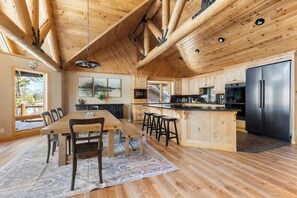 A spacious kitchen with wooden cabinetry, a central island, and stainless steel appliances.