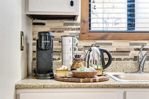 A kitchen with a Keurig coffee maker, a kettle, a coffee grinder, and a coffee pot on the counter. - Condo with Fireplace & River Views, Mill Run (Quechee)