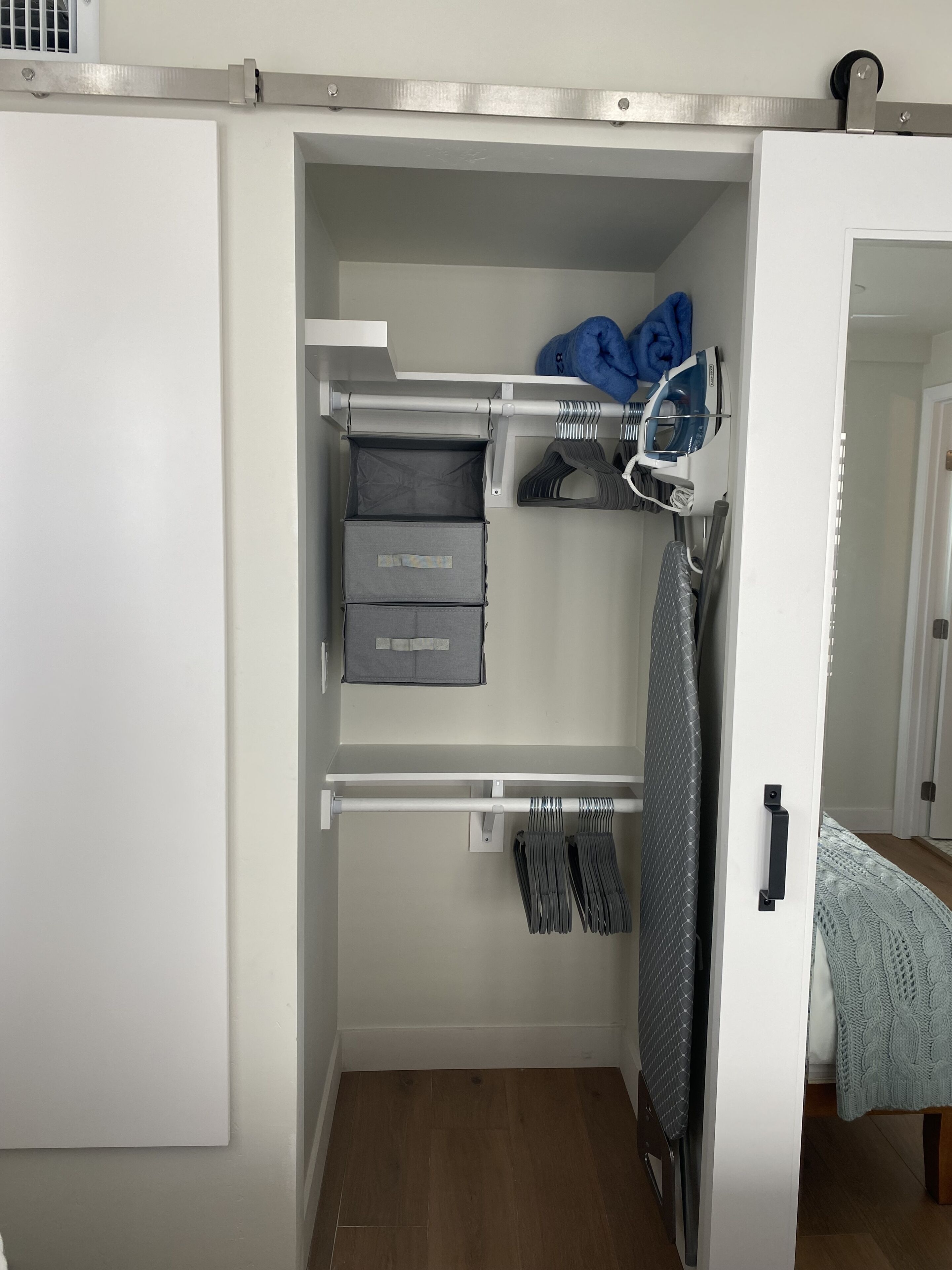 A walk-in closet with hanging space, shelves, and a shoe rack.
