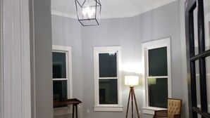 Une pièce avec un plancher en bois, un lampadaire et une chaise.