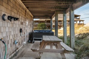 Relax on the patio with a hot tub nearby, surrounded by natural scenery.