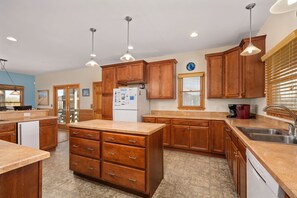 Enjoy cooking in this well-equipped kitchen with a central island, refrigerator, coffee maker, and dishwasher.