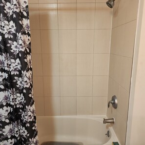 Een bad/douchecombinatie, toiletpapier