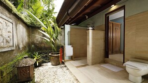 A bathroom with a toilet, shower, and decorative plants. - Villa Inka Ubud by Nakula (Ubud)