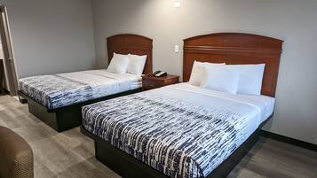 Dos camas individuales con ropa de cama estampada en una habitación de hotel.