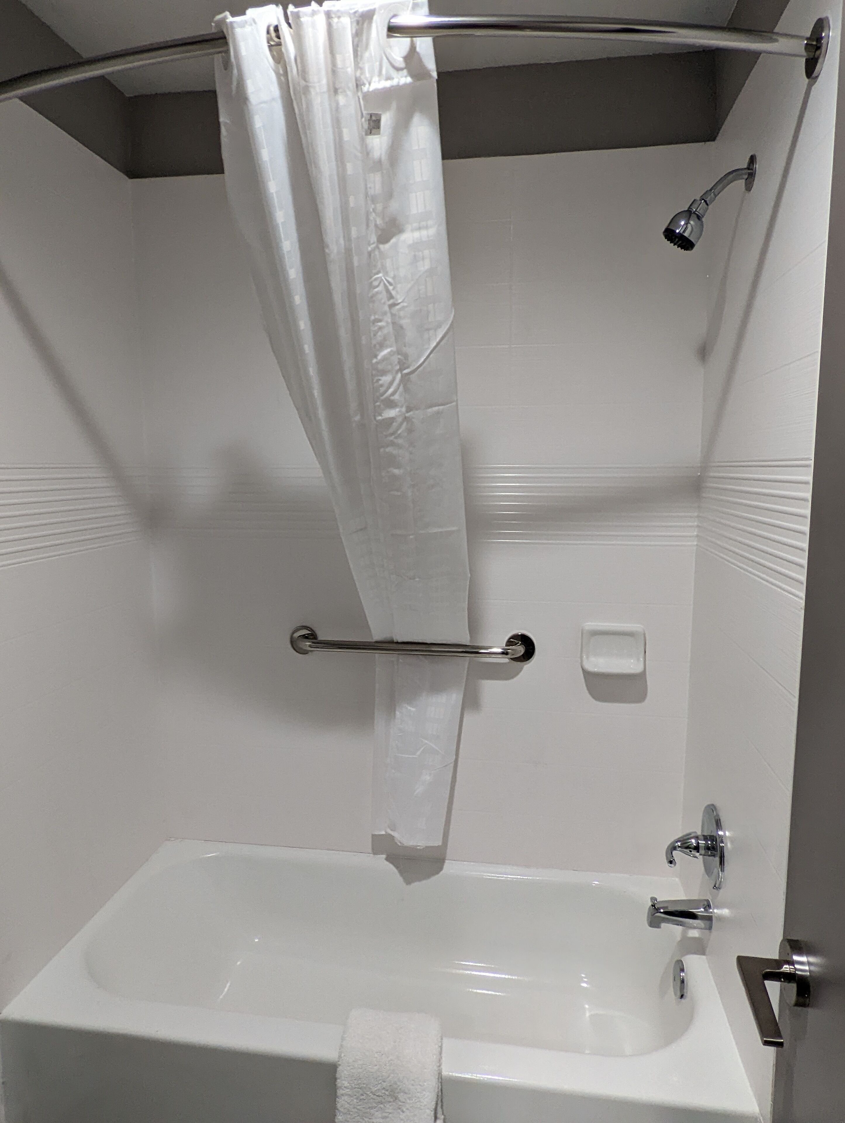 Une salle de bain avec une baignoire, une douche et un porte-serviettes.