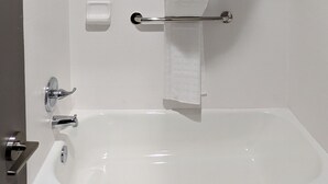 A modern bathroom with a shower, a bathtub, and a toilet. - OKC Hotel (Oklahoma City)