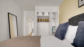 Une chambre d’hôtel avec un lit, une armoire et un couloir.