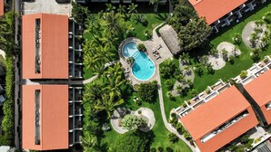 An aerial view of a resort with multiple buildings, a swimming pool, and well-maintained gardens. - Jardines del Mar 3 (Oranjestad)