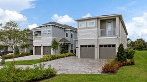 A two-story house with a stone facade, a garage, and a landscaped front yard. - The Perfect Villa with a beautiful Private Pool, Orlando Villa 5601 (Orlando)