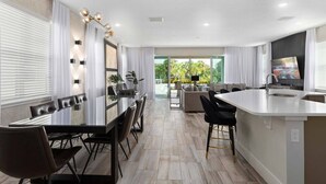 A modern kitchen with a dining area, large windows, and a view of greenery outside. - The Perfect Villa with a beautiful Private Pool, Orlando Villa 5601 (Orlando)