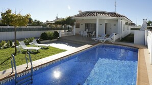 Ein Pool mit Liegestühlen und einer Terrassenanlage.