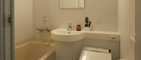 A small, compact bathroom with a bathtub, toilet, and sink.