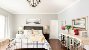 A bedroom with a bed, bedside tables, a dresser, a chandelier, and artwork on the walls. - Amazing & Relaxing 5B3B-Private Pool (Monrovia)