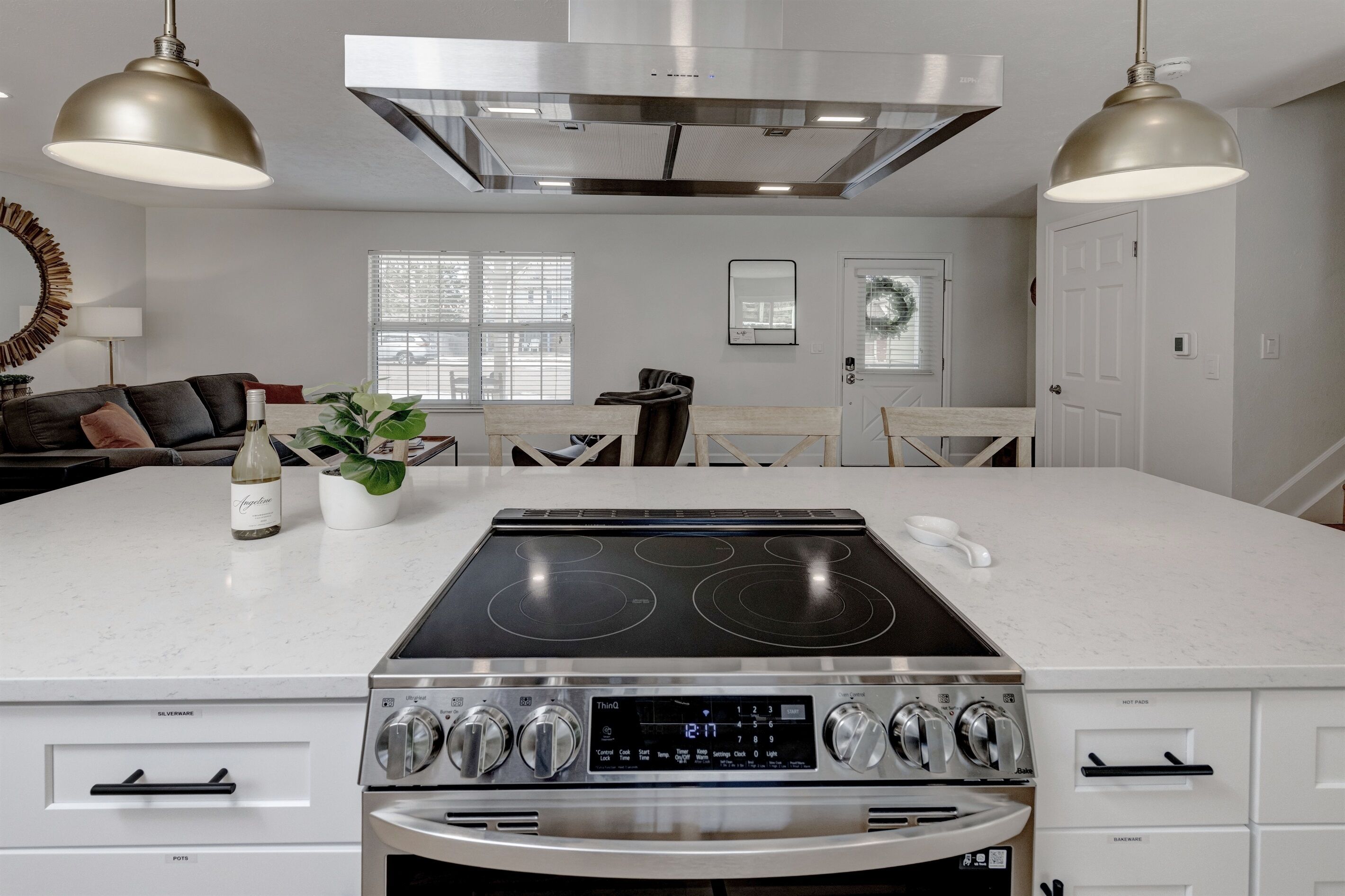 A modern kitchen with a central island, stainless steel appliances, and pendant lighting.