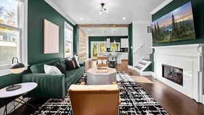 Uma sala de estar moderna com um sofá verde, uma mesa de centro e uma lareira.
